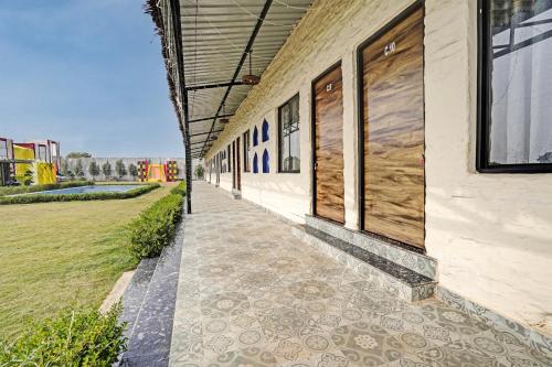 a building with a walkway next to a field at Hotel O New Friends Hotel in Prayagraj