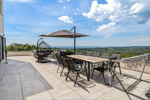 a patio with a table and chairs and an umbrella at Luxury Villa with Indoor Pool and Sauna in Zagreb