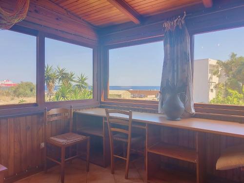 a room with a table and chairs and windows at Holiday Home Posidonie by Interhome in LʼÎle-Rousse