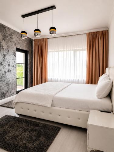 a bedroom with a large white bed and a window at Grey House in Bucharest