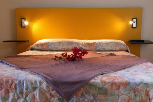 un lit avec une composition florale en haut dans l'établissement Résidence Eglantine, à Cilaos