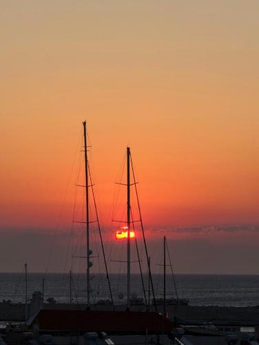 a sunset over the ocean with sailboats in a harbor at Nautilus City Studios & Apartments in Rhodes Town