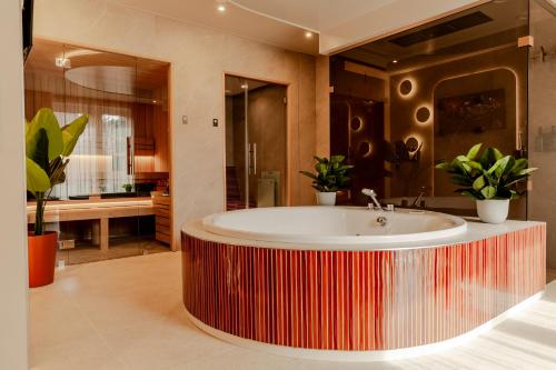 a bathroom with a tub with plants in it at Boutique Hotel Charley's in Westkapelle