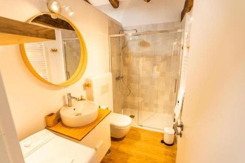 a bathroom with a sink and a toilet and a mirror at La Cueva Rural Boutique Villa in La Focella