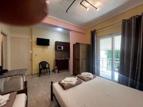 a bedroom with two beds and a room with a window at Armonia Studio in Paralia Katerinis
