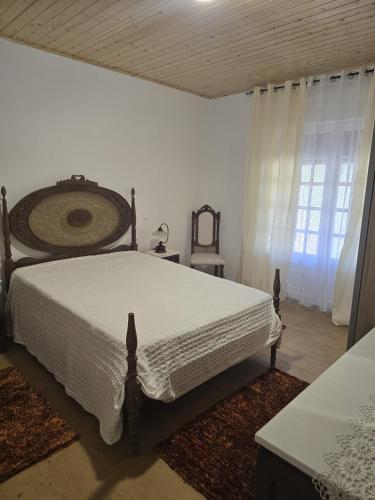 a bedroom with a white bed and a window at Quinta Real Kiwibee in Barrô