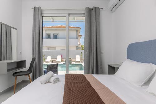 a bedroom with a bed and a view of a pool at Villa Vibella in Laganas
