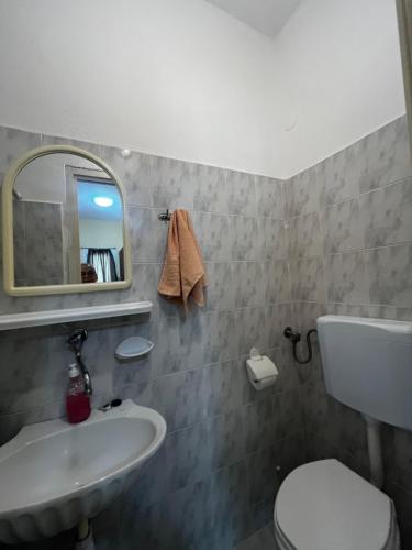 a bathroom with a sink and a toilet and a mirror at Armonia Studio in Paralia Katerinis