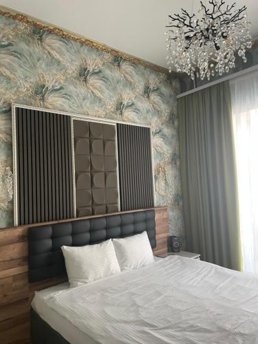 ein Schlafzimmer mit einem großen Bett und einem Kronleuchter in der Unterkunft Siena Hotel in Odessa