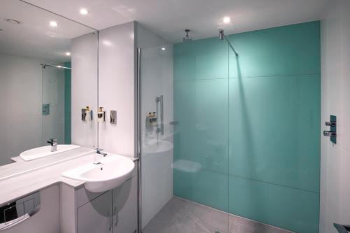 a bathroom with a sink and a glass shower at De Vere Horsley Estate in East Horsley