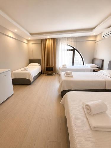 a large hotel room with three beds at Viyana Pansiyon in Çeşme