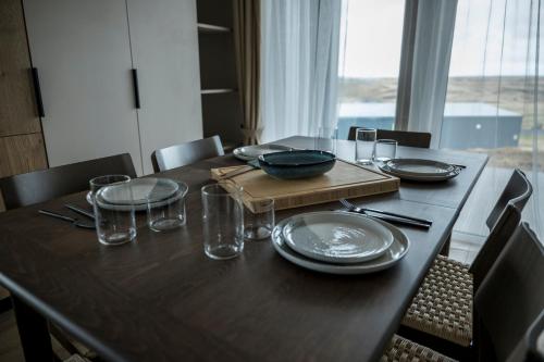 a wooden table with plates and glasses and a bowl on it at Hestheimar in Hella