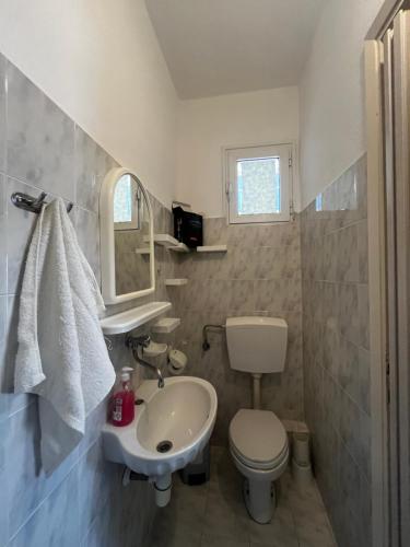 a bathroom with a sink and a toilet and a mirror at Hermes Studio in Paralia Katerinis