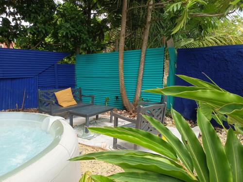 a backyard with a tub and a bench and a blue fence at Ma chambre Javanaise in Port-Louis