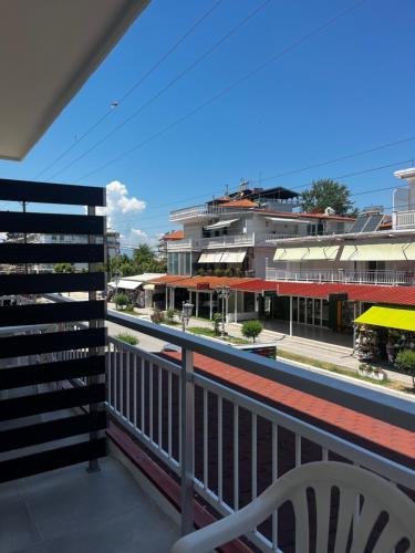 a balcony with a white chair and a building at Eleni Studio in Paralia Katerinis