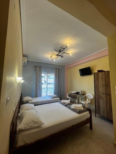 a bedroom with two beds in a room with a window at Eleni Studio in Paralia Katerinis