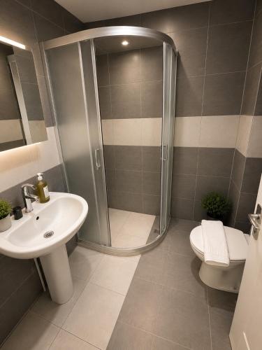 a bathroom with a shower and a sink and a toilet at Viyana Pansiyon in Çeşme