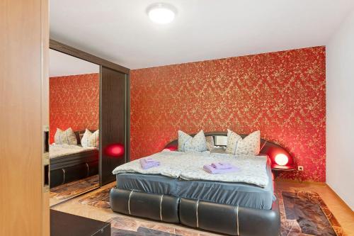 a bedroom with a bed and a red wall at Ferienwohnung sehr ruhig in Pößneck