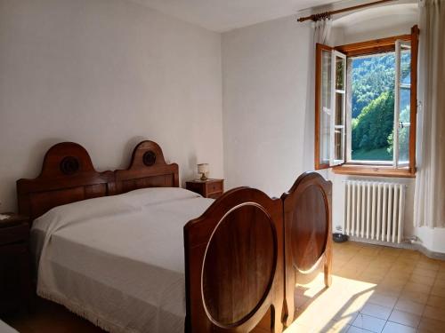a bedroom with a bed and a window at Casa nel Borgo Iris in Breguzzo