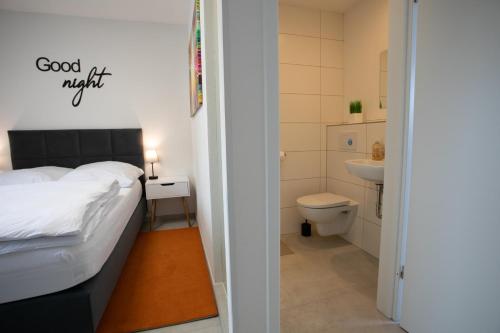 a bedroom with a bed and a bathroom with a toilet at Walters Weidelbach in Haiger