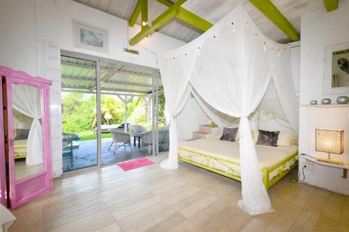 a bedroom with a bed with a canopy at Villa Lorizon in Rodrigues Island
