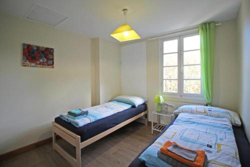 a bedroom with two beds and a window at Le moulin in Saint-Yrieix-la-Perche