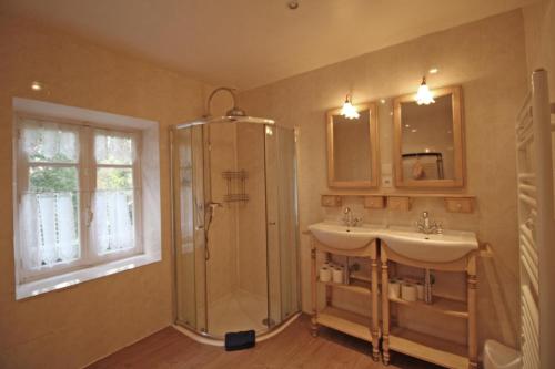 a bathroom with two sinks and a shower at Le moulin in Saint-Yrieix-la-Perche