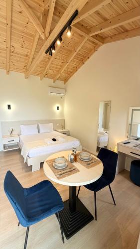 a bedroom with a bed and a table and chairs at Aurea in Dhërmi