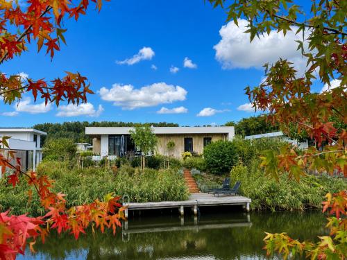 a house on the water with a dock at Harderwold Villa - 412 in Zeewolde