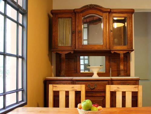a wooden cabinet with a bowl of fruit on a table at Cabañas Estancia Balumba in Capilla del Monte