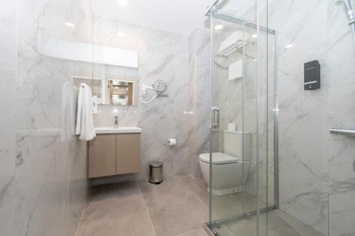 a bathroom with a shower and a toilet and a sink at Dorana Toro Hotel in Kyrenia