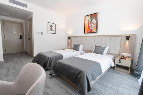 a hotel room with two beds and a chair at Dorana Toro Hotel in Kyrenia