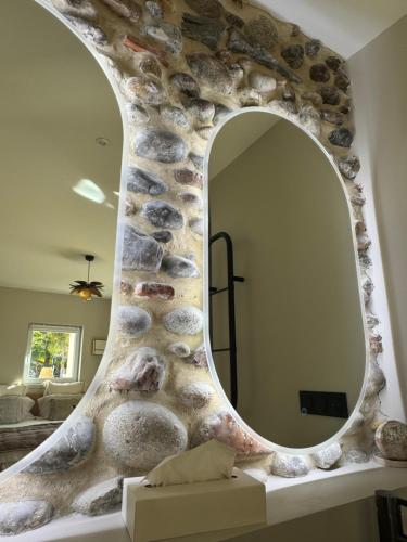a mirror in a room with a stone wall at Maison Maün in Gelos