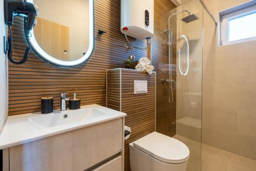 a bathroom with a toilet and a sink and a shower at Guest house AnĐela in Neum
