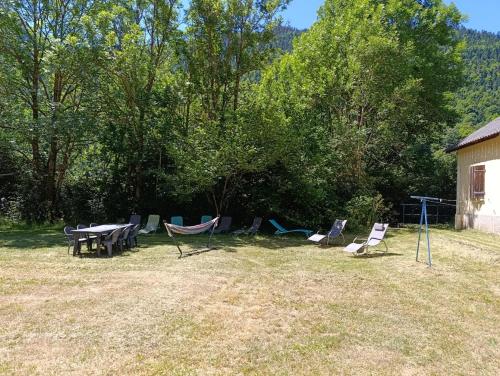 a group of chairs and a picnic table in a yard at Gîte Espace et Montagne in Aragnouet