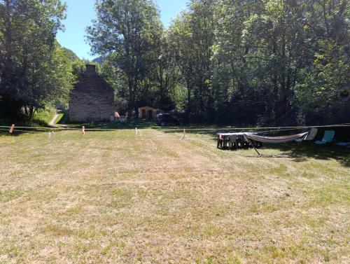 a yard with a hammock in front of a house at Gîte Espace et Montagne in Aragnouet