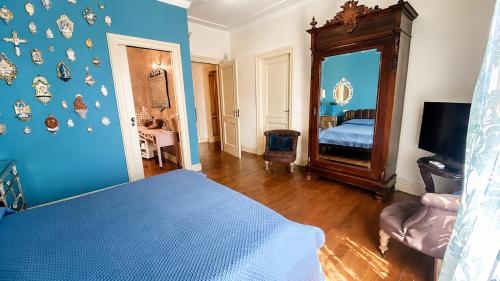a blue bedroom with a bed and a mirror at The Queens House in Agrigento