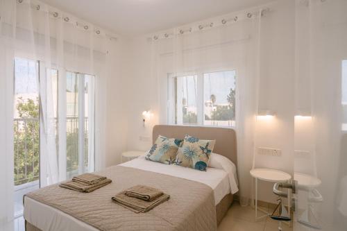 a white bedroom with a bed with two pillows on it at Myrtiana 10 in Oroklini