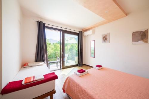 two beds in a room with a window at Casa Vacanze Al Cielo 2 in Sarnano