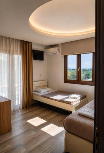 a bedroom with two beds and a large window at Studios Apartments Irini Patira in Potos