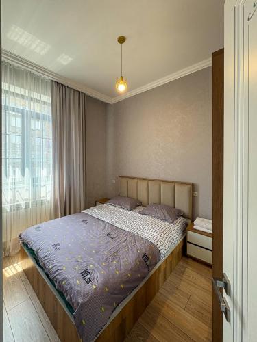 ein Schlafzimmer mit einem Bett mit blauer Bettdecke in der Unterkunft Luxury Leo Apartment Sevan in Sewan