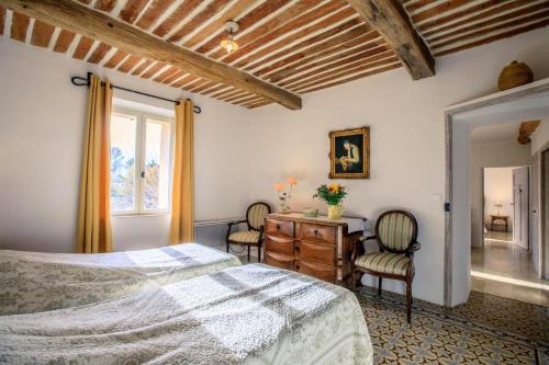 a bedroom with a bed and two chairs and a desk at La bastide d'emilie sud est in Saint Antonin du Var