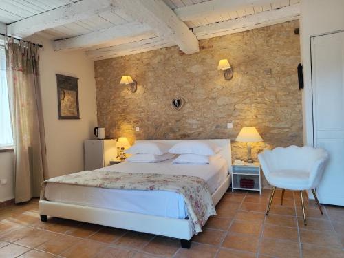 a bedroom with a bed and a stone wall at Bastide De Luzert in Labastide-de-Lévis