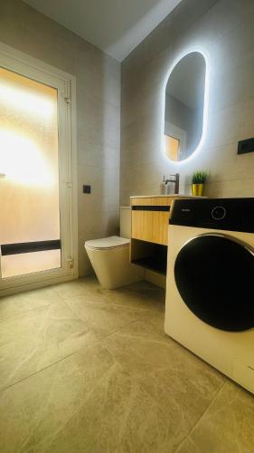 a bathroom with a sink and a washing machine at Aurah Home in Tudela