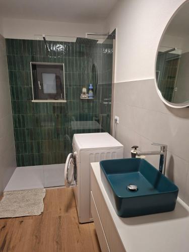 a bathroom with a blue sink and a shower at La Casa di Mimma in Badolato