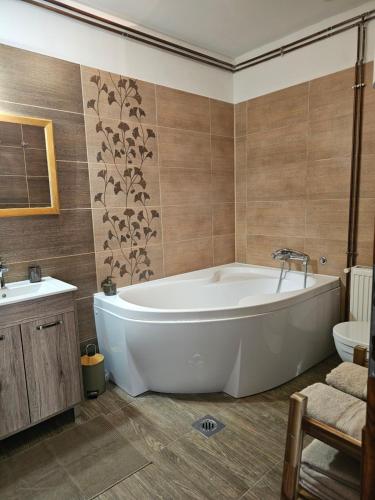 a bathroom with a large tub and a sink at Kapolcsi Kuckó in Kapolcs