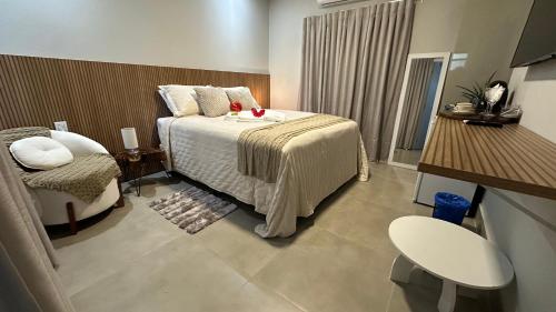 a hotel room with a bed and a chair at Pousada raios de sol in Chapada dos Guimarães