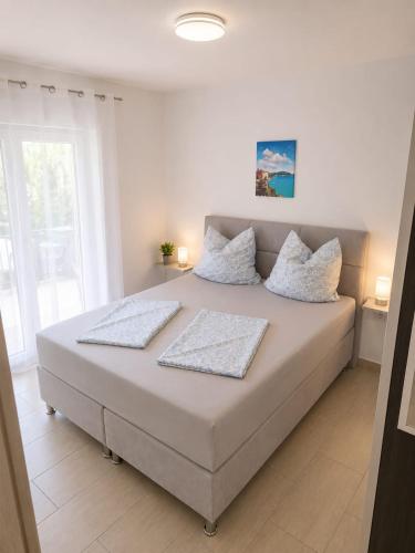 a bed with two pillows on it in a bedroom at Apartments Adria in Vir