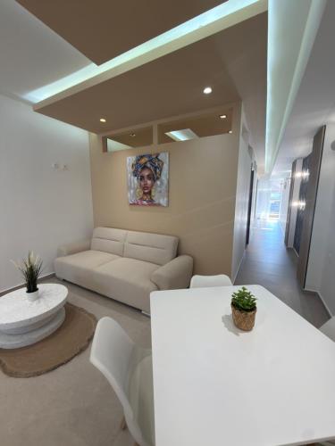 a living room with a white couch and a table at Lux In A Box, Apartments In the center in Nea Kallikrateia