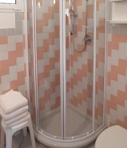 a bathroom with a shower with a stool and towels at Hotel Dolores in Rimini